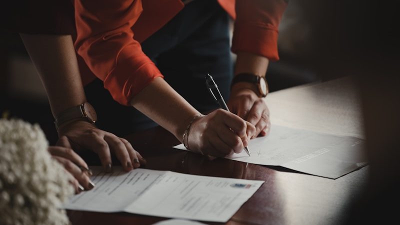 Dos personas cumplimentando un impreso sobre una mesa