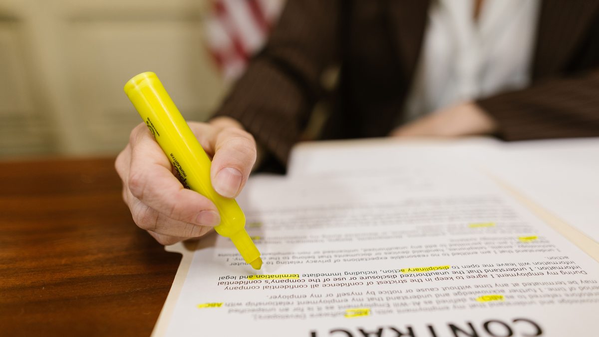 Contrato de trabajo impreso siendo subrayado con un rotulador